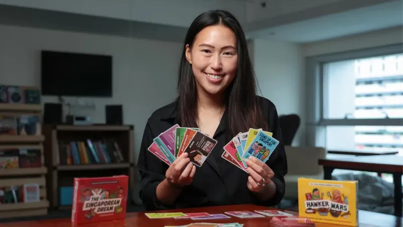 She doesn't scramble for housing or compete for KPIs; instead, she's using board games to achieve her ‘Singapore dream'
